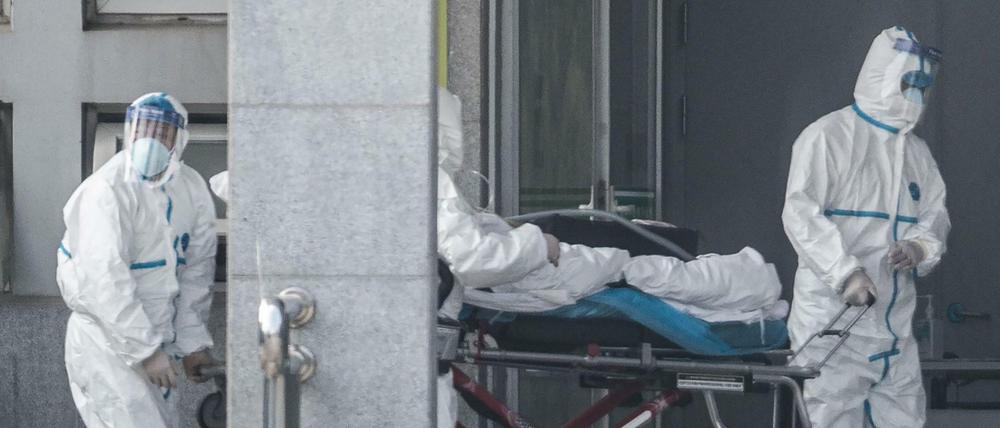 In Quarantäne: Medizinisches Personal bringt einen Patienten in ein Krankenhaus im chinesischen Wuhan.