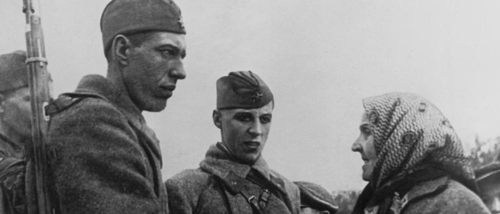 Eine alte Bauersfrau begrüßt die Soldaten der Roten Armee in Molodeczno (heute Maladsetschna in Weißrussland) während des Vormarsches der Truppen.