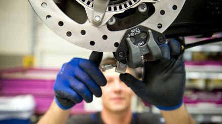 Ein Mann im BMW-Motorradwerk in Berlin in der Produktion. 