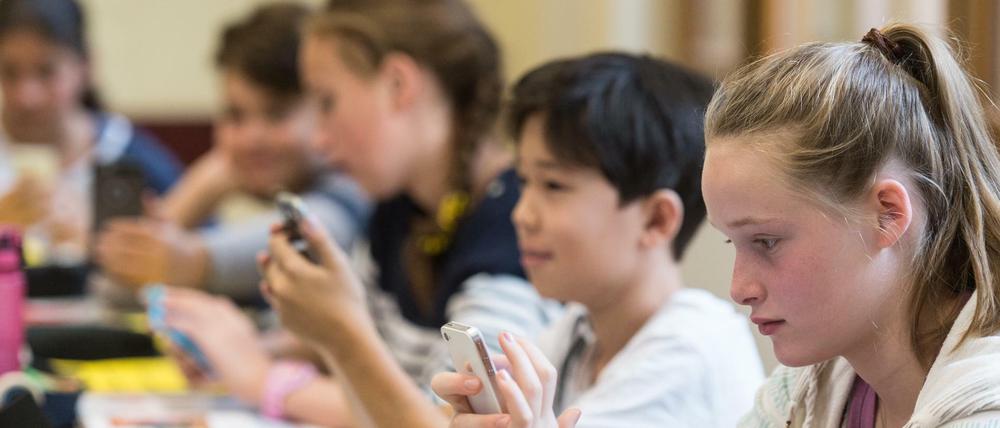 Schüler am Smartphones (Symboldbild). 