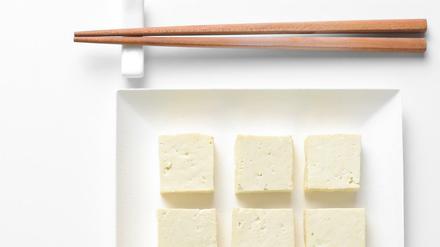 Tofu diced and served in a square plate, flat lay, view from above, space for a text