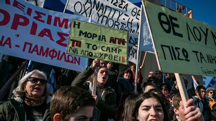 "Der Ort Moria fordert, das Camp Moria muss entfernt werden!" steht auf einem der Schilder, das Einheimische auf der Insel Lesbos im Mittelmeer bei der Demo am Hafen hochhielten. 