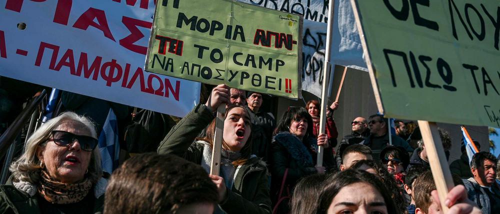 "Der Ort Moria fordert, das Camp Moria muss entfernt werden!" steht auf einem der Schilder, das Einheimische auf der Insel Lesbos im Mittelmeer bei der Demo am Hafen hochhielten.