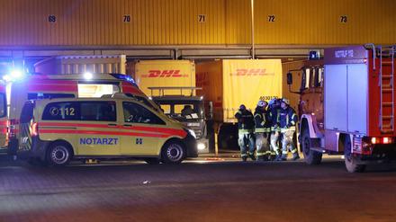 Feuerwehrleute und ein Notarztwagen nahe der Stelle, an der ein Lastwagenfahrer auf einem Betriebsgelände gestorben ist. 