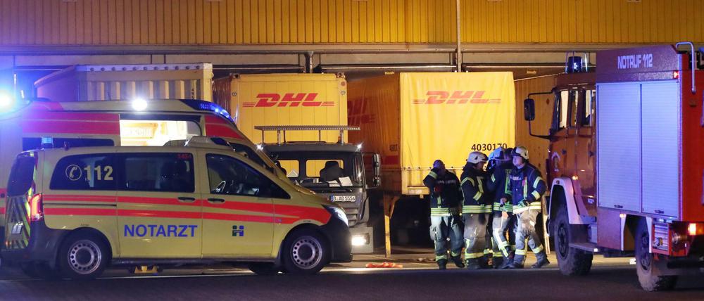 Feuerwehrleute und ein Notarztwagen nahe der Stelle, an der ein Lastwagenfahrer auf einem Betriebsgelände gestorben ist.
