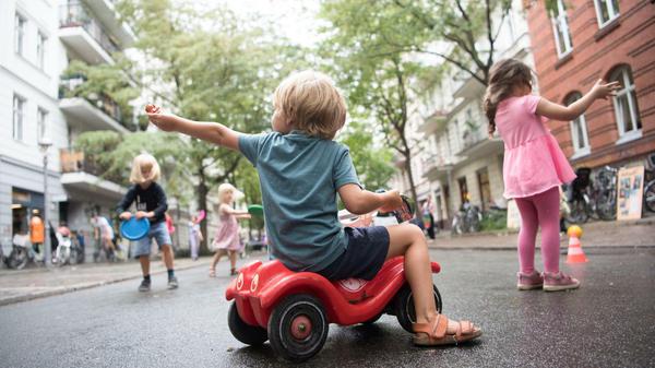 Kinder spielen auf einer Straße.