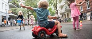 Kinder spielen auf einer Straße.