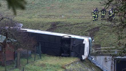 Thüringen, Berka vor dem Hainich: Rettungskräfte stehen neben einem verunglückten Schulbus.