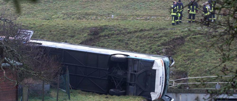 Thüringen, Berka vor dem Hainich: Rettungskräfte stehen neben einem verunglückten Schulbus.