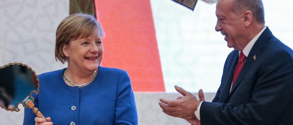 Staatspräsident Erdogan übergibt Kanzlerin Merkel als Geschenk einen antiken Spiegel.