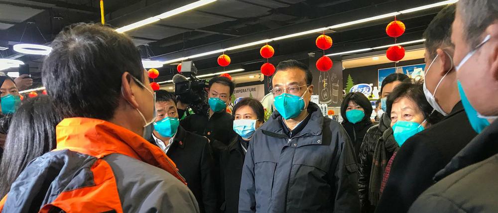 Chinas Regierungschef Li Keqiang (Mitte) spricht mit Bewohner der unter Quarantäne stehenden Stadt Wuhan. 