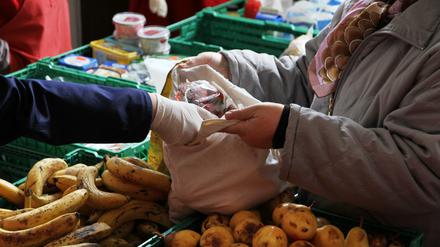 Eine Mitarbeiterin der Berliner Tafeln verteilt Obst an Bedürftige.