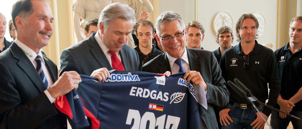 Oft Erfolg gehabt. Billy Flynn als Geschäftsführer der Eisbären (links) neben Berlins damaligen Regierendem Bürgermeister Klaus Wowereit und Eisbären Manager Peter John Lee halten das Meister-Trikot der Eisbären Berlin im Rotem Rathaus in Berlin. 