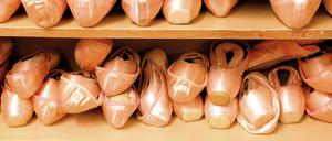 Unzählige Ballettschuhe in einem Regal.