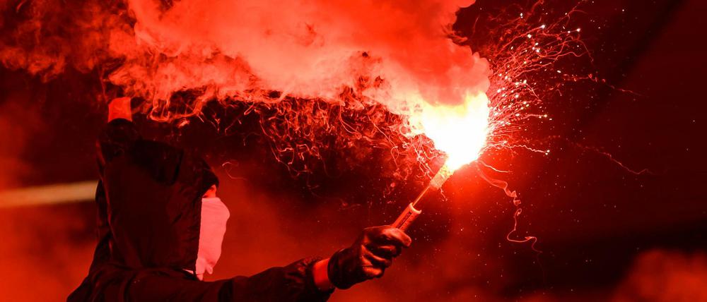 Ein Demonstrant zündet Pyrotechnik. (Symbolbild)
