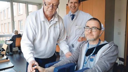 Muskeln aufbauen. Ergotherapeut Jürgen Dahm, Chefarzt Martin Ebinger und Patient Nils Pfeiffer in Aktion. 