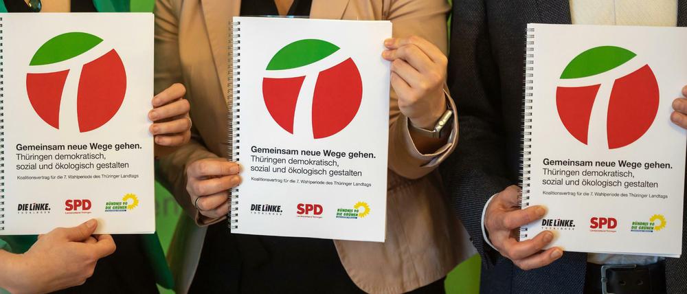 Die neue Thüringer Koalition zeigt nach der Unterzeichnung den gemeinsamen Regierungsvertrag.