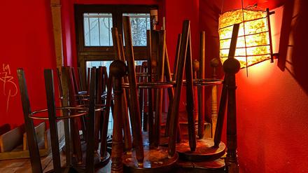 Bar stools are stacked on the tables of a cafe which is only open for take aways in Berlin's Kreuzberg district on December 8, 2020 amid the novel coronavirus COVID-19 pandemic. (Photo by DAVID GANNON / AFP)