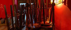 Bar stools are stacked on the tables of a cafe which is only open for take aways in Berlin's Kreuzberg district on December 8, 2020 amid the novel coronavirus COVID-19 pandemic. (Photo by DAVID GANNON / AFP)