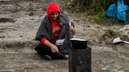 Eine Mutter und ihr Kind in einem improvisierten Lager beim Camp Moria auf Lesbos versuchen sich zu wärmen.