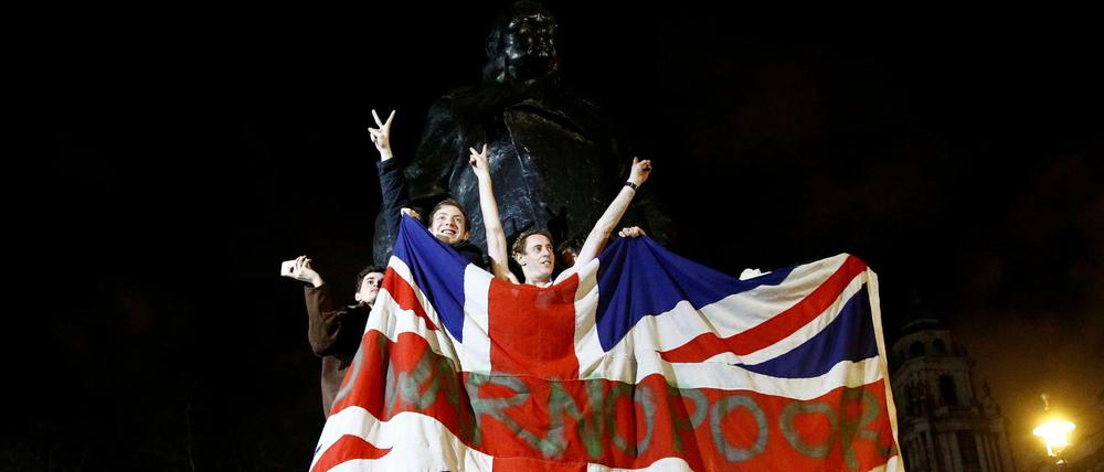 Briten feiern vor einer Statue Winston Churchills in London den Brexit.