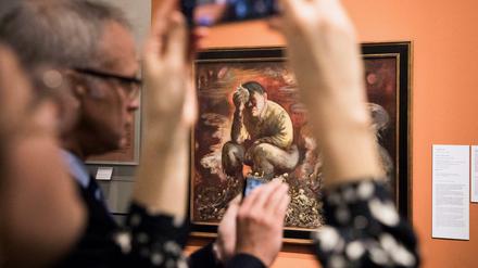 Besucher fotografieren das Gemälde "Cain or Hitler in Hell" des Malers George Grosz im Deutschen Historischen Museum.