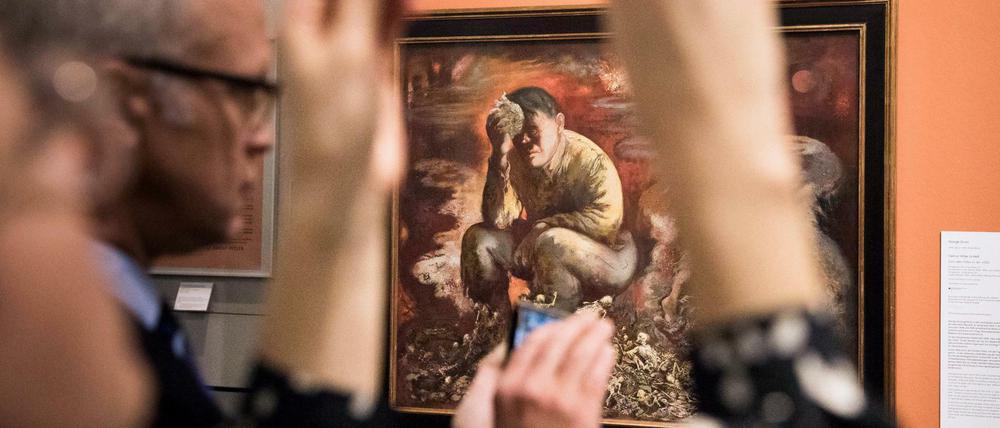 Besucher fotografieren das Gemälde "Cain or Hitler in Hell" des Malers George Grosz im Deutschen Historischen Museum.