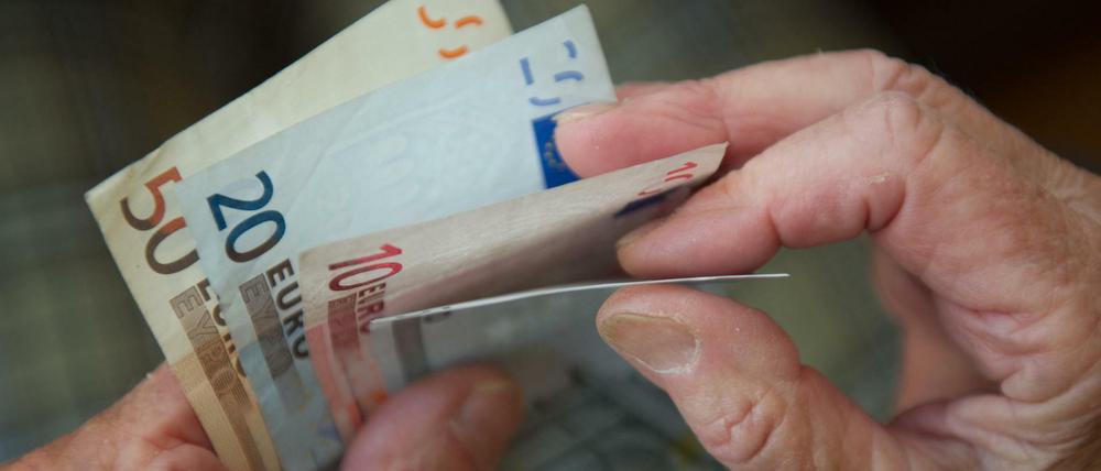 Eine ältere Frau zählt Geld. 