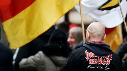 Ein Demonstrant steht zwischen Deutschlandfahnen bei einer Demonstration der Partei "Die Rechte".