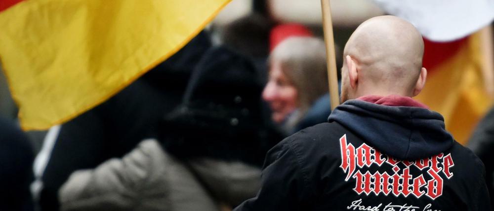 Ein Demonstrant steht zwischen Deutschlandfahnen bei einer Demonstration der Partei "Die Rechte".