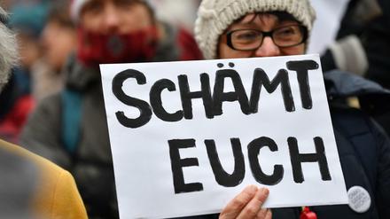 06.02.2020, Thüringen, Erfurt: Eine Frau mit einem Schild "Schämt euch" demonstriert gegen die Wahl Kemmerichs zum Ministerpräsidenten von Thüringen. Der FDP-Kandidat Kemmerich war am 05.02.2020 im Thüringer Landtag überraschend mit den Stimmen von Liberalen, CDU und AfD zum Regierungschef gewählt worden. 