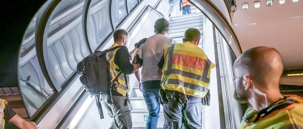 Polizeibeamte begleiten einen Afghanen auf dem Flughafen Leipzig-Halle in ein Charterflugzeug (Symbolbild).
