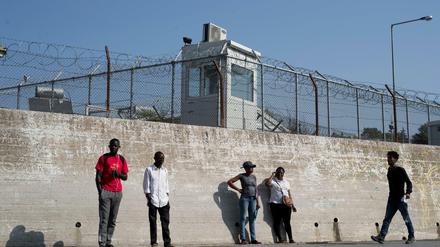 Eine Gruppe von Migranten an einer Mauer des Flüchtlingslagers Moria auf Lesbos. 