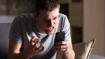 Wütender Mann mit seinem Smartphone.