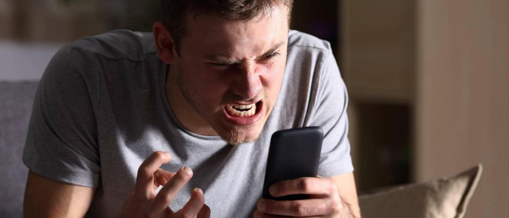 Wütender Mann mit seinem Smartphone.