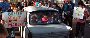 10.11.1989, Berlin: Mit selbstgemalten Plakaten wird dieser Trabi auf der Bösebrücke von den West-Berlinern begrüßt. Nach der Öffnung eines Teiles der deutsch-deutschen Grenzübergänge reisten Millionen DDR-Bürger zu einem kurzen Besuch nach West-Berlin und in die Bundesrepublik Deutschland. 