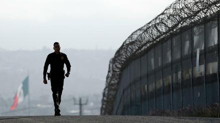 Der US-Grenzpolizist Eduardo Olmos läuft entlang des Zauns an der Grenze zwischen USA und Mexiko in San Diego (USA). 
