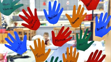 Aus Folien geschnittene Kinderhände hängen mit den jeweiligen Namen an der Eingangstür. Die Brandschutztür fehlt.