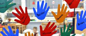 Aus Folien geschnittene Kinderhände hängen mit den jeweiligen Namen an der Eingangstür. Die Brandschutztür fehlt. 