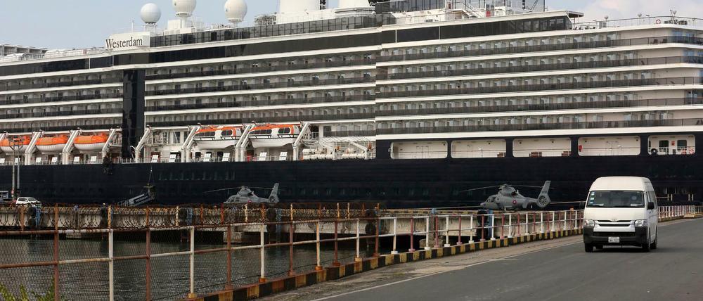 Das Kreuzfahrtschiff „Westerdam“ liegt im Hafen von Sihanoukville, Kambodscha. Davor stehen zwei Hubschrauber des kambodschanischen Militärs. Bei Passagieren des Schiffs war am Wochenende überraschend eine Infektion mit dem Coronavirus festgestellt worden.