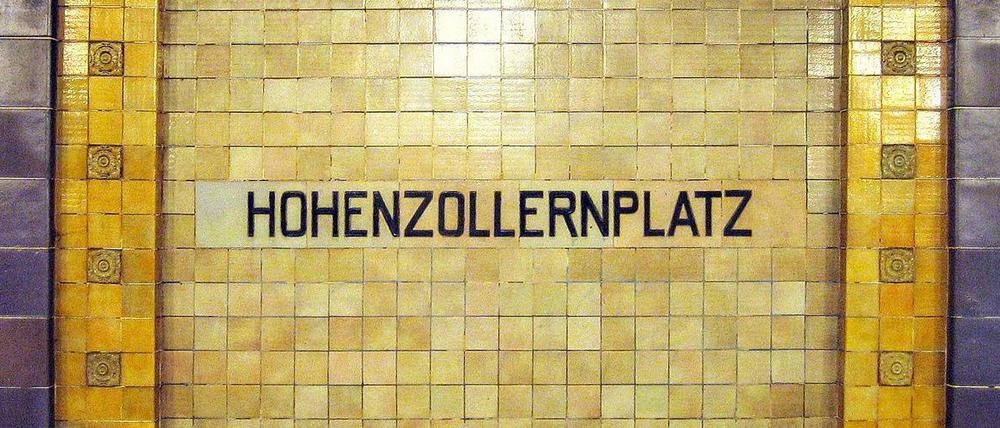 Historisches Stationsschild in den Farben gelb und violett im U-Bahnhof Hohenzollernplatz.