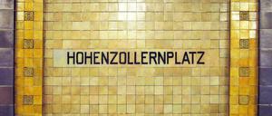 Historisches Stationsschild in den Farben gelb und violett im U-Bahnhof Hohenzollernplatz.