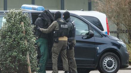 Eine Person wird von Polizisten zum Bundesgerichtshof gebracht.