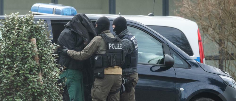 Eine Person wird von Polizisten zum Bundesgerichtshof gebracht.