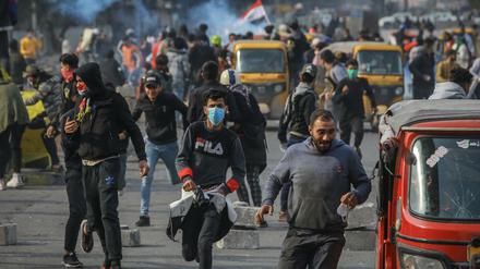 Regierungskritische Demonstranten fliehen bei Zusammenstößen mit Sicherheitskräften in Bagdad, Irak. Seit Monaten gehen die Iraker gegen die Regierung auf die Straße und protestieren gegen Misswirtschaft und Korruption.