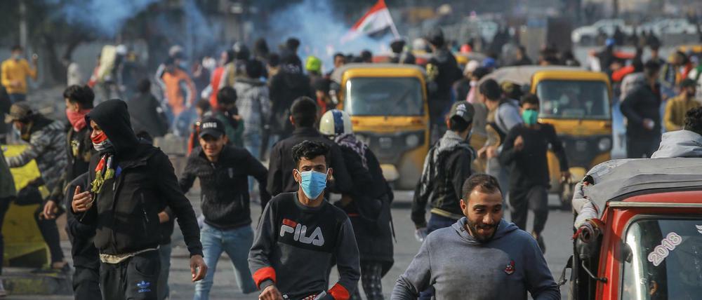 Regierungskritische Demonstranten fliehen bei Zusammenstößen mit Sicherheitskräften in Bagdad, Irak. Seit Monaten gehen die Iraker gegen die Regierung auf die Straße und protestieren gegen Misswirtschaft und Korruption.