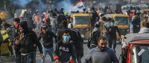 Regierungskritische Demonstranten fliehen bei Zusammenstößen mit Sicherheitskräften in Bagdad, Irak. Seit Monaten gehen die Iraker gegen die Regierung auf die Straße und protestieren gegen Misswirtschaft und Korruption.