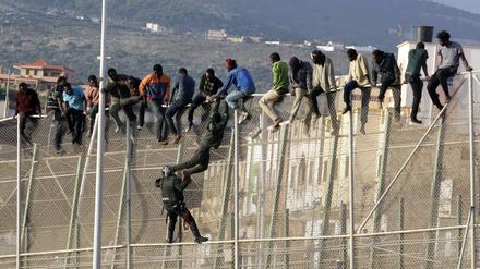 Flüchtlinge auf dem Grenzzaun um die spanische Enklave Melilla in Marokko.
