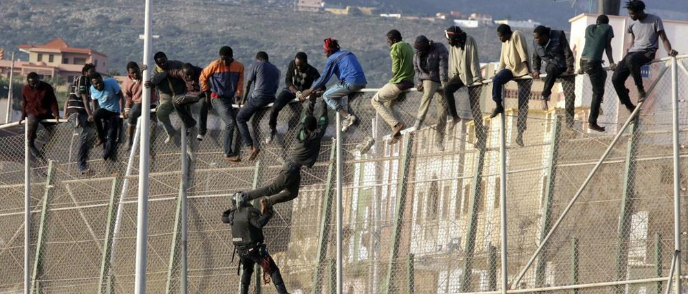 Flüchtlinge auf dem Grenzzaun um die spanische Enklave Melilla in Marokko.