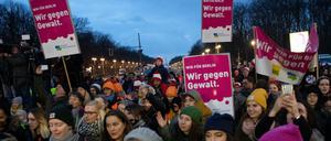 Teilnehmer an der Tanz-Demo "One billion Rising Revolution" stehen am Brandenburger Tor.